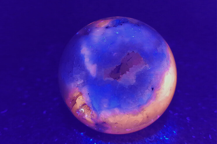 Manganocalcite sphere with drusis under UV-light