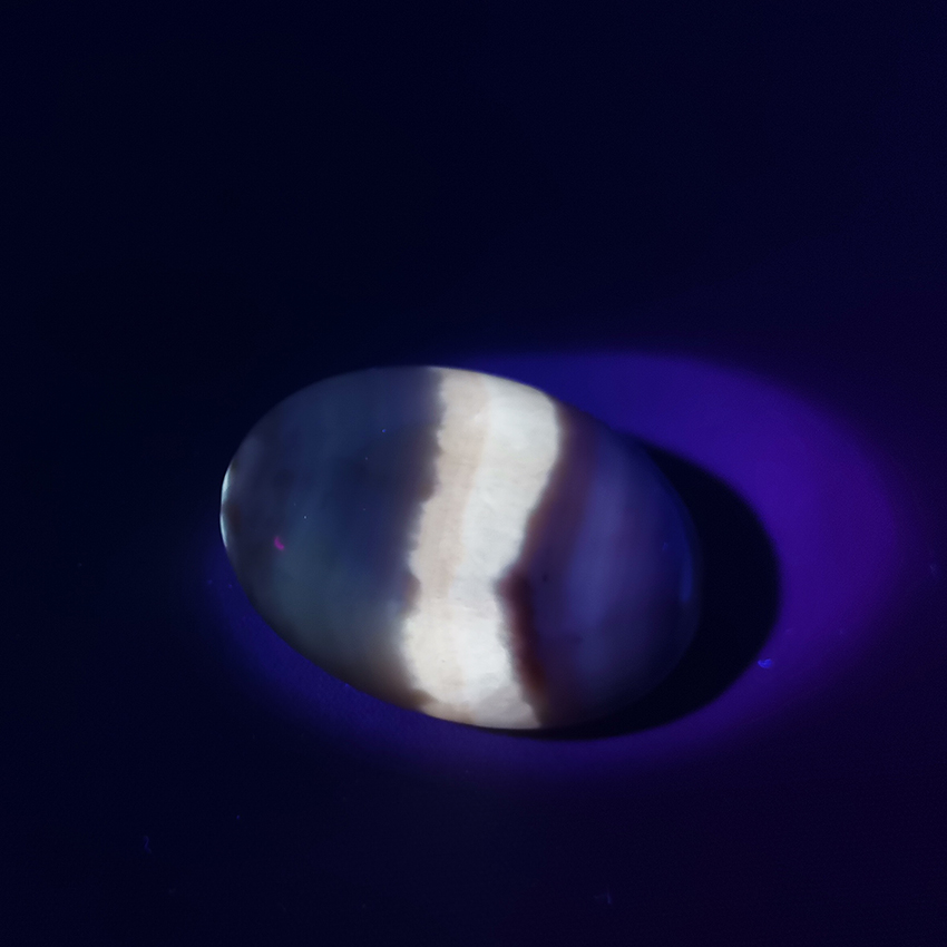 coati aragonite worry stone 02 under UV light